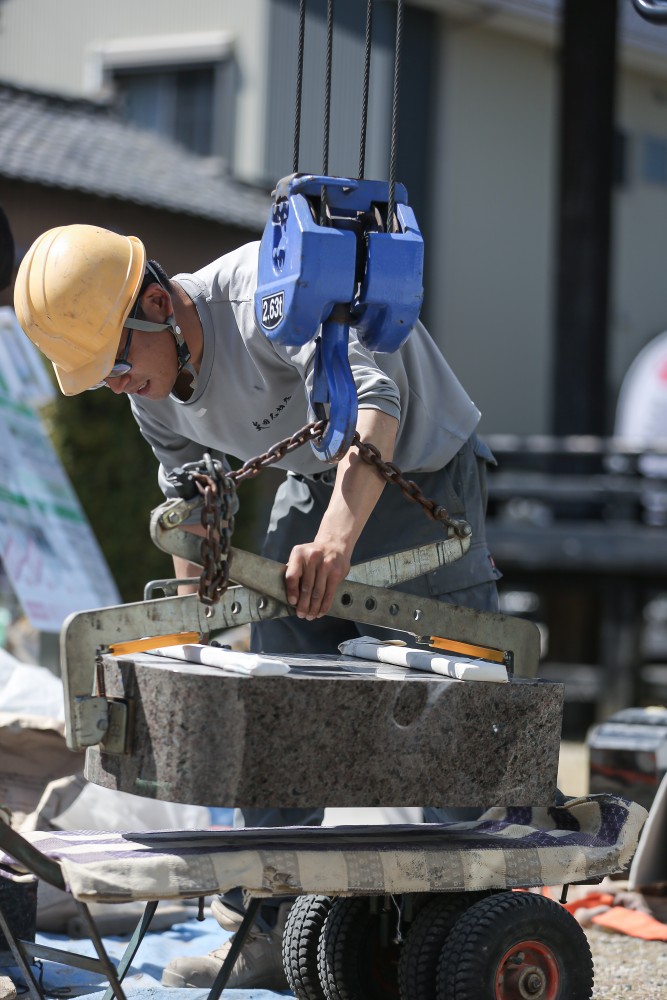美浜町の墓地で墓石設置を行う矢田石材店の職人