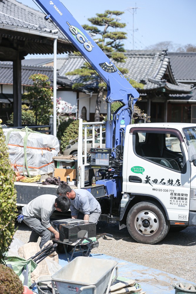 矢田石材店の職人が墓石を設置している様子